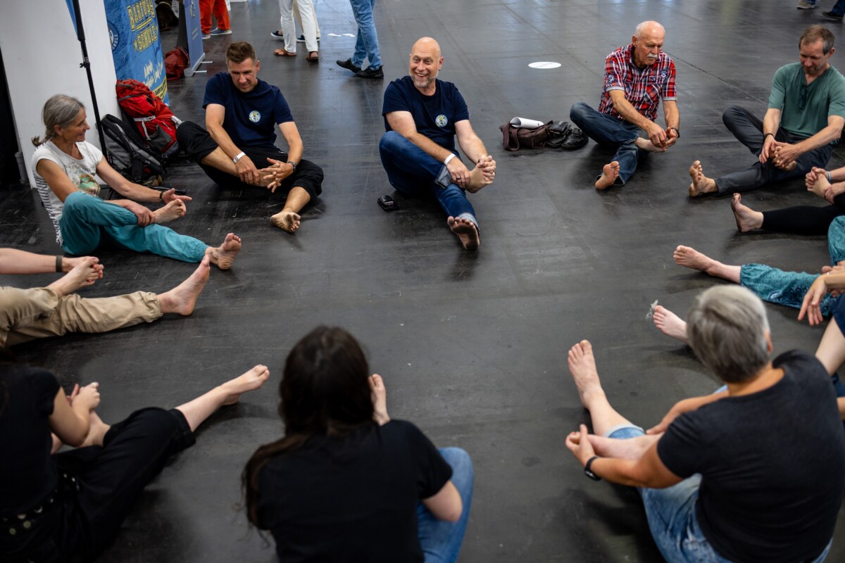 Workshop participants sitting in a circle and working on their feet, photo by Messe Offenbach / Esra Klein